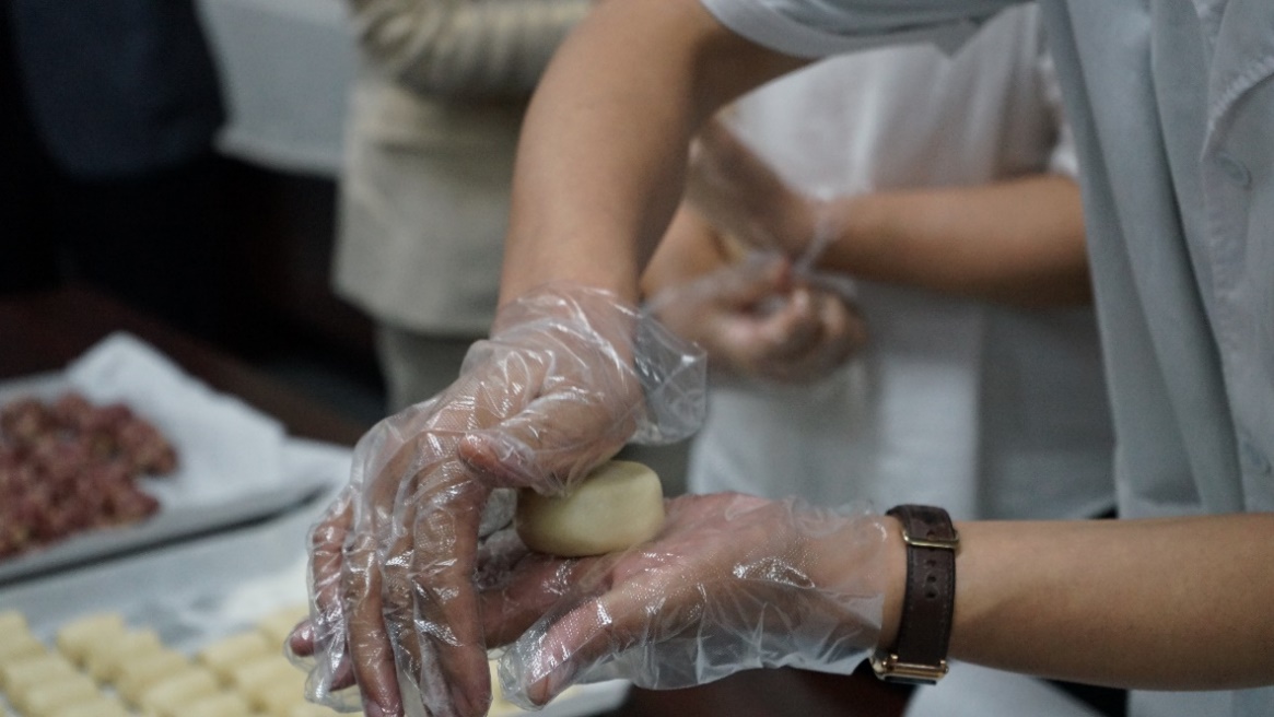 按扁面团、加入馅料、揉搓成型，糕点师傅现场制作手工月饼。人民网记者 栗翘楚摄