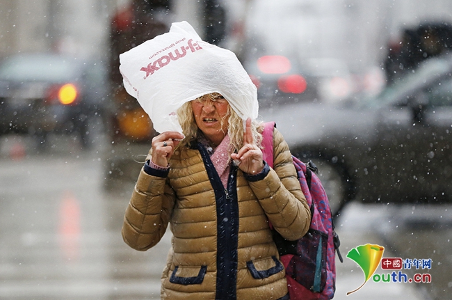 美国芝加哥地区四月飘雪行人头顶塑料袋挡雪